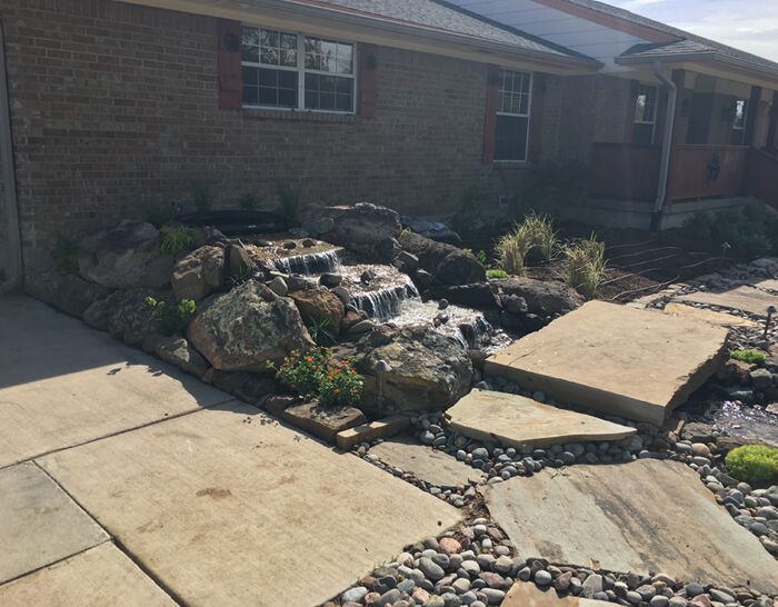 A custom waterfall water feature and landscaping that we designed and built