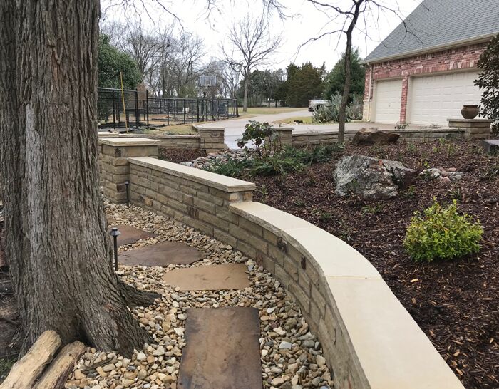 A custom retaining wall, flagstone pavers and flower bed we designed and built
