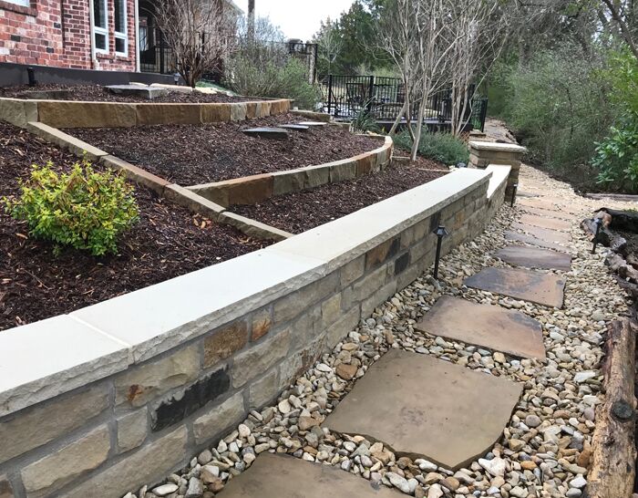 A custom retaining wall, flagstone pavers and flower bed we designed and built