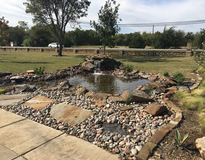 A custom water fall water feature, pond and landscaping that we designed and built
